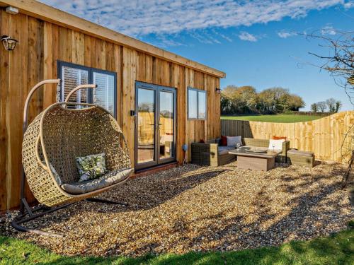 a large rattan swing sitting outside of a house at Log Cabin near Bath in Chippenham