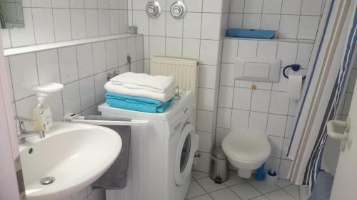 バーデン・バーデンにあるMöbliertes Apartment am Festspielhausの白いバスルーム(洗濯機、シンク付)