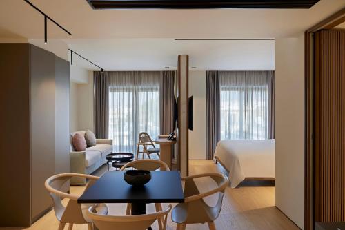 a hotel room with a bed and a table and chairs at Dusit Suites Hotel Athens in Athens