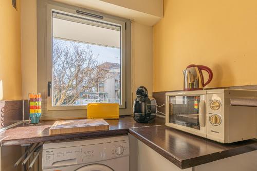 a kitchen with a microwave and a window at Appartement vue mer Arcachon in Arcachon