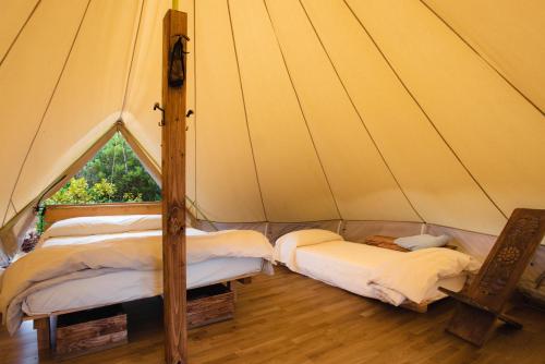 two beds in a canvas tent with a window at ecoVita agri-glamping in San Vito