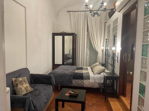a living room with a bed and a couch at CASA PERIN - HOSTAL RURAL in Villafranca de los Barros
