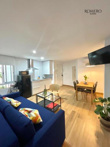 Romero Suites 1 في قرطبة: غرفة معيشة مع أريكة زرقاء وطاولة