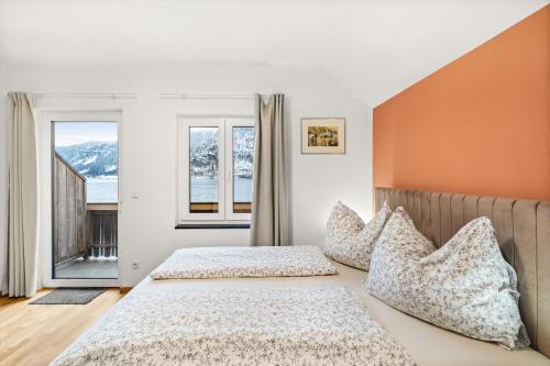 two beds in a room with two windows at Hallstatt Lakeside Top 5 - Zimmer mit Balkon in Hallstatt