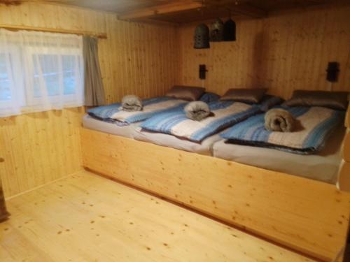 1 Schlafzimmer mit 2 Betten in einem Holzzimmer in der Unterkunft Hütte Waldesruh in Kaltenberg