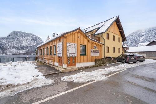 a building in a parking lot with snow at Hallstatt Lakeside Top 5 - Zimmer mit Balkon in Hallstatt