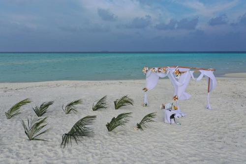 a wedding arch on the beach near the ocean at Blue Wave Hotel Maldives in Kudahuvadhoo