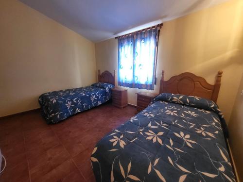 1 dormitorio con 2 camas y ventana en Casa rural CASA DEL CERRO, en Casas del Cerro