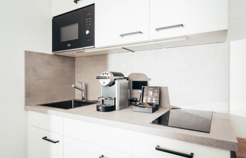 a kitchen with a sink and a microwave at kalm stay - munich east in Munich