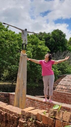 a woman standing on steps next to a statue at Vineyard Guest House in Taitung City