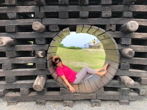 a woman laying in a hole in a wooden structure at Vineyard Guest House in Taitung City