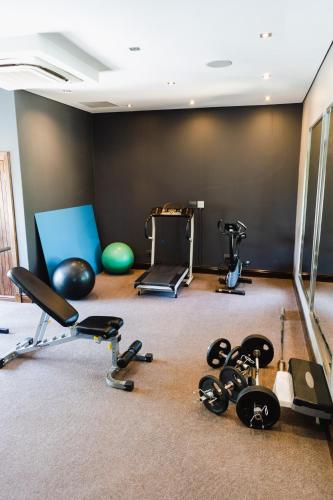 a gym with several exercise equipment in a room at Tredenham Boutique Hotel in Bloemfontein