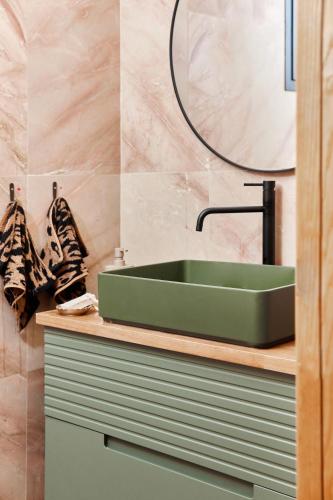 a bathroom with a green sink and a mirror at Villa Balfour in Eilat
