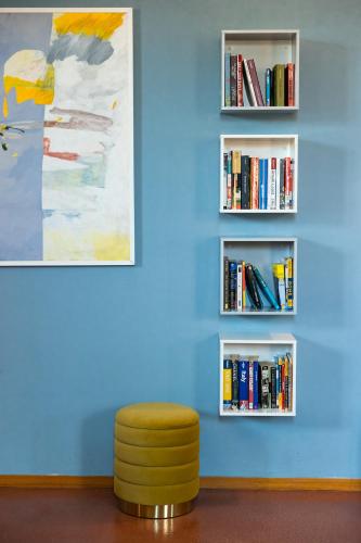 a stool in front of a blue wall with books at Navona 49 Luxury Suites&Apartment in Rome