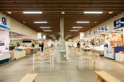a grocery store with white chairs and tables in it at Destiny Inn Sakaiminato in Sakaiminato
