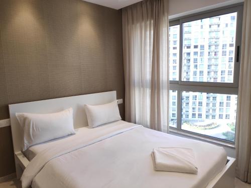 a bedroom with a large white bed with a window at Maxxvalue Apartment Hiranandani Powai in Mumbai