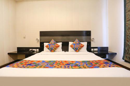 a bedroom with a large white bed with colorful pillows at FabHotel Posh Classic in Gurgaon