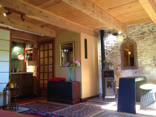 Elle comprend un salon doté d'une cheminée et d'un plafond en bois. dans l'établissement gîte pour amoureux ambiance Japon, à Rebourguil