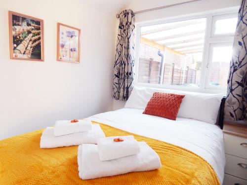 1 dormitorio con 1 cama con toallas en Modern, well located en-suite rooms with parking and all facilities en Cambridge
