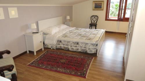 カステッランマーレ・デル・ゴルフォにあるIl Giardino Monticcioloのウッドフロアのベッドルーム1室(ベッド1台、ラグ付)