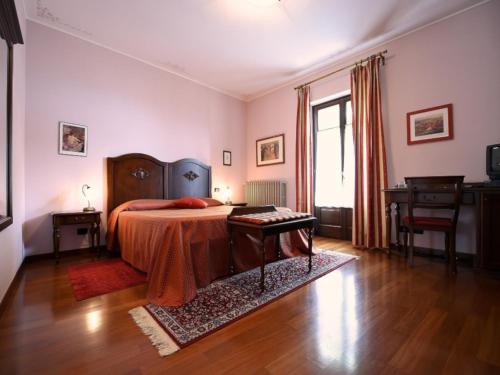 Schlafzimmer mit einem Bett, einem Tisch und einem Fenster in der Unterkunft tra Arte e Querce in Monchiero
