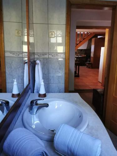 a bathroom with a sink and a large mirror at Alojamento Local Madre de Cima in Vinhais
