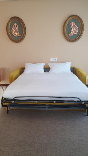 a large bed in a room with two pictures on the wall at OMAMA Hotel in Aosta