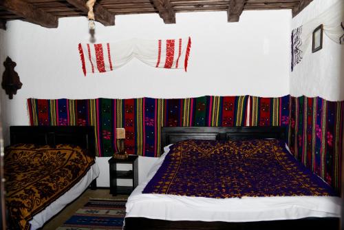 1 dormitorio con 2 camas en una habitación con paredes coloridas en Satu Muscelean, en Albeștii de Muscel