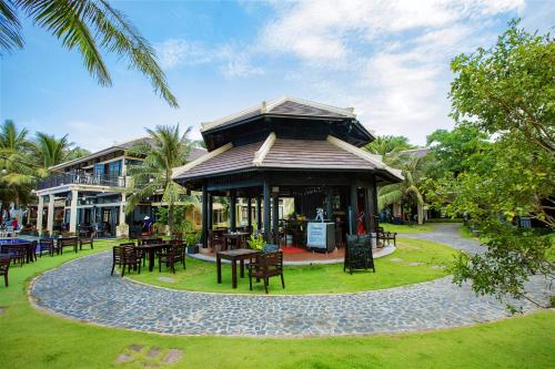 a restaurant with tables and chairs in a park at Anja Beach Resort & Spa in Phu Quoc
