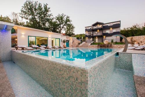a swimming pool in front of a house at VILLA G., Relaxing and Unique nest of Enjoyment in Imotski