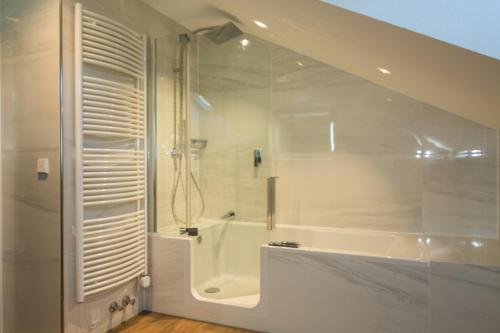 a white bathroom with a shower and a tub at Hotel Garni Jägerhof in Sigmaringen