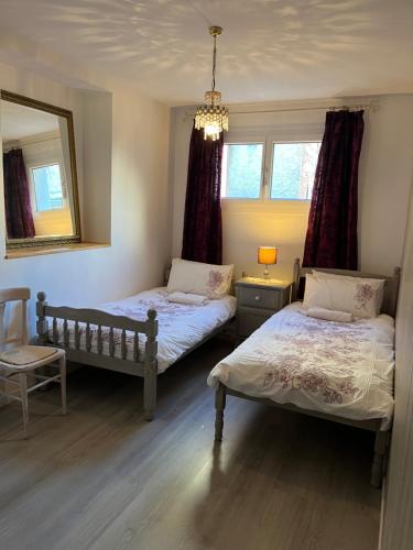 a bedroom with two beds and a mirror at Boutique Appartement 2 Chambres dans le Vieux Cahors in Cahors