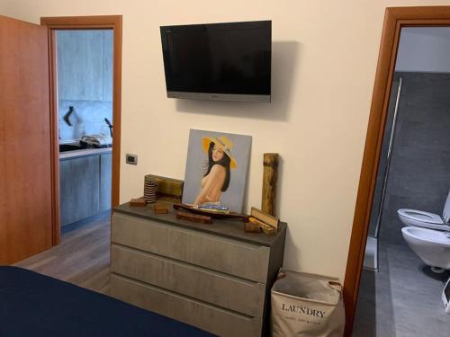 a bedroom with a dresser with a television on the wall at Attico con terrazzo. in Parma