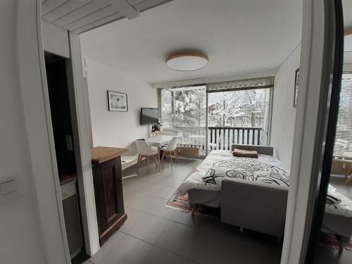 une chambre avec un lit, une table et une fenêtre dans l'établissement studio quartier calme centre ville vue mont Blanc, à Chamonix-Mont-Blanc