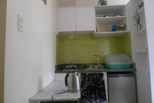a small kitchen with a sink and a stove at Amabel's Condo Unit K 2LC in Baguio