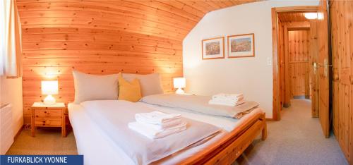 a bedroom with a bed in a wooden cabin at Furkablick Alice und Yvonne by Arosa Holiday in Arosa