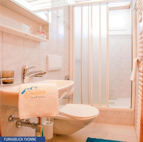 ein Bad mit einem WC, einem Waschbecken und einer Dusche in der Unterkunft Furkablick Alice und Yvonne by Arosa Holiday in Arosa