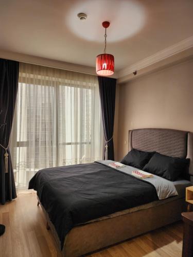 Luxury apartment in Istanbul في إسطنبول: غرفة نوم بسرير كبير مع نافذة كبيرة