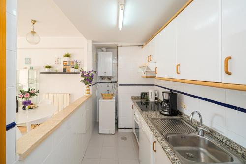una pequeña cocina con fregadero y nevera. en Alborada Golf 1 3D Spaniahome, en Albir