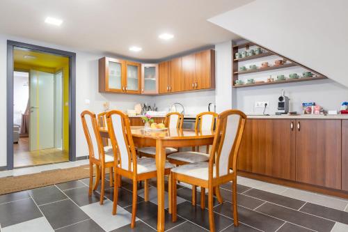 cocina con mesa de madera y sillas en Barkóscinege Vendégház, en Géberjén