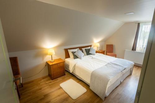 a bedroom with a large white bed and a window at Barkóscinege Vendégház in Géberjén