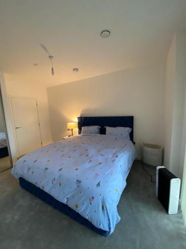 a bedroom with a bed with a blue comforter at Amazing new built townhouse with garden in London in Hendon