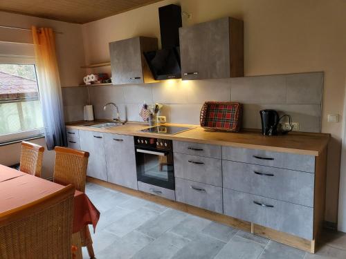 a kitchen with a sink and a stove top oven at Ferienhaus Heidekate in Munster im Heidekreis