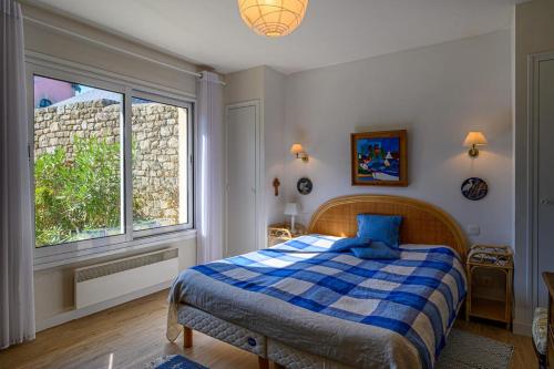 a bedroom with a bed and a large window at “Maison en bord de mer à Loctudy avec vue sur le jardin." in Loctudy