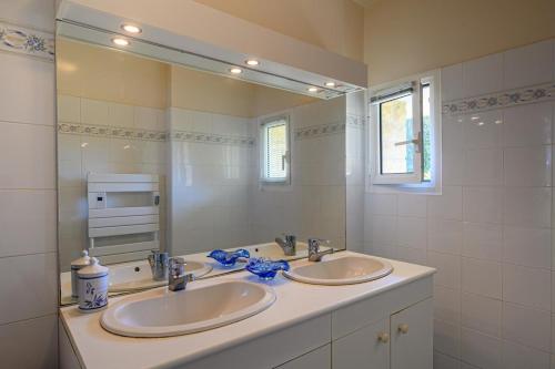 a bathroom with two sinks and a large mirror at “Maison en bord de mer à Loctudy avec vue sur le jardin." in Loctudy