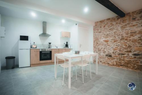 een keuken met een witte tafel en witte stoelen bij Appartement neuf et moderne dans le centre ville in Bagnols-sur-Cèze