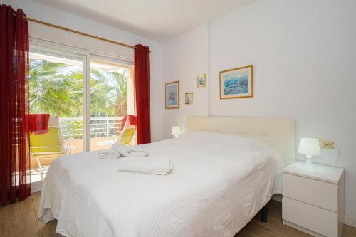 a bedroom with a white bed and a window at Alborada Golf 3 1A Spaniahome in Albir