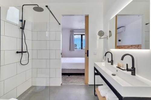 克拉倫代克的住宿－Belnem House Bonaire，带淋浴、盥洗盆和镜子的浴室