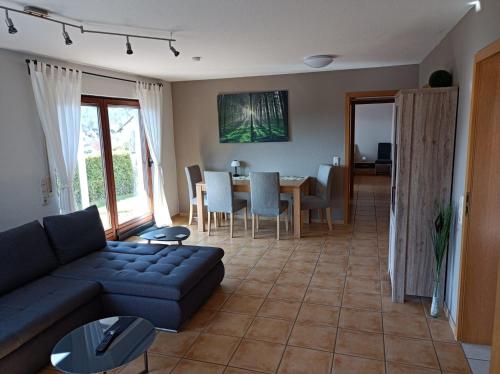 uma sala de estar com um sofá azul e uma mesa em Fewo-Kuhn Bad Berleburg em Bad Berleburg