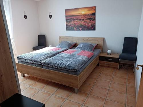 um quarto com uma cama e duas cadeiras em Fewo-Kuhn Bad Berleburg em Bad Berleburg